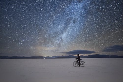Free Man Riding Bicycle on Snow Covered Ground during Night Time Stock Photo