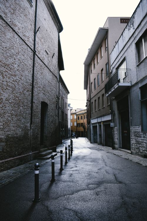 Free A serene view of a cobblestone street in Italy, flanked by classic buildings. Stock Photo