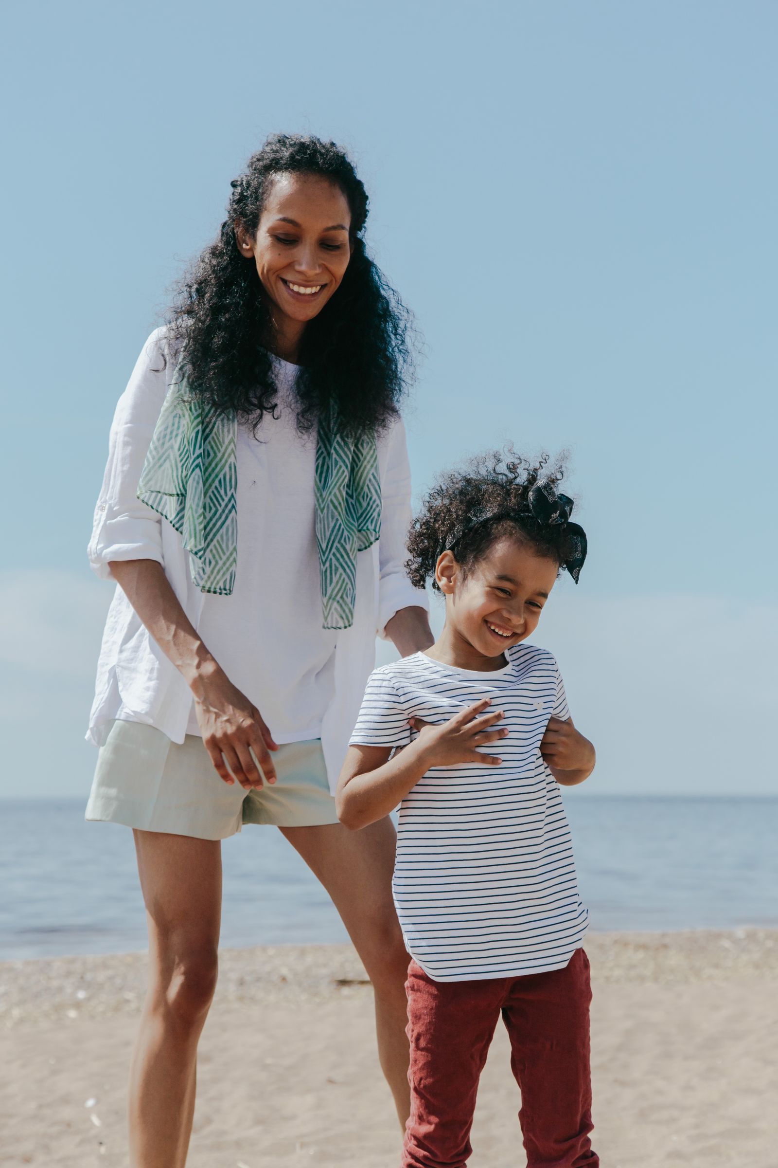 Mère et enfant qui jouent sur la plage au soleil