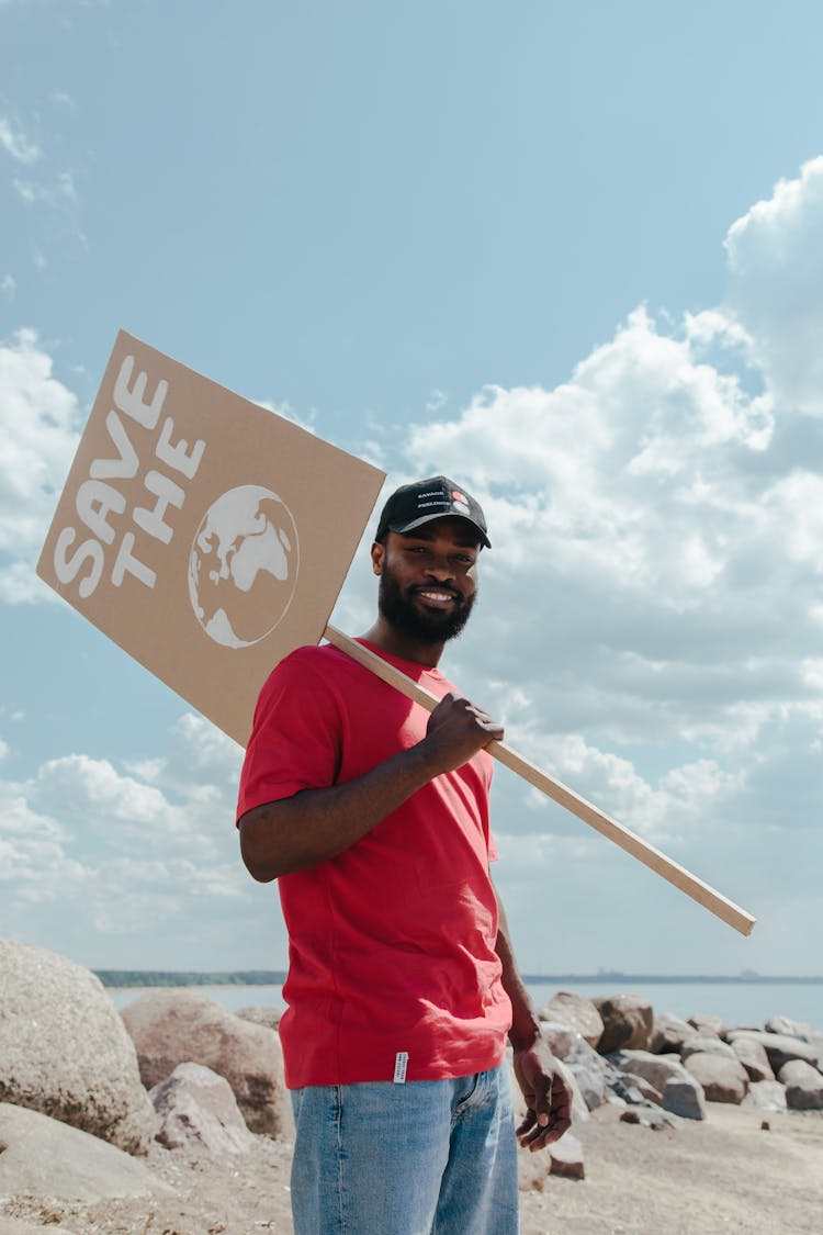 A Man In Red Shirt Holding A Poster