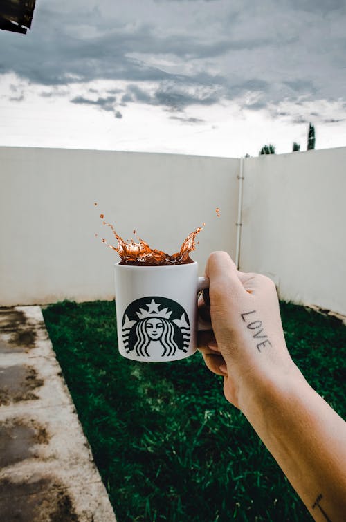 Free Person Holding Starbucks Cup With Brown Beverage Stock Photo