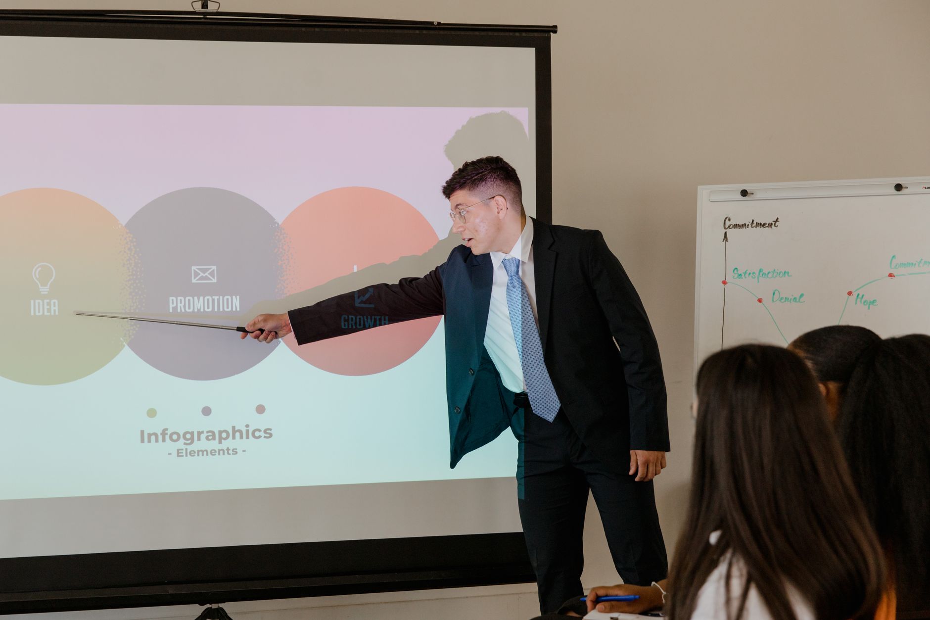 Professional giving presentation using infographic in an office meeting.