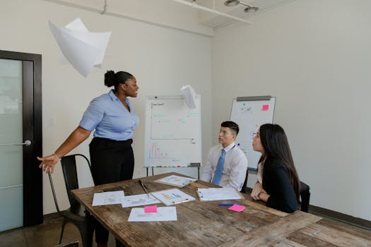 A group of colleagues engaged in a lively discussion in a modern office setting, emphasizing teamwork and collaboration.