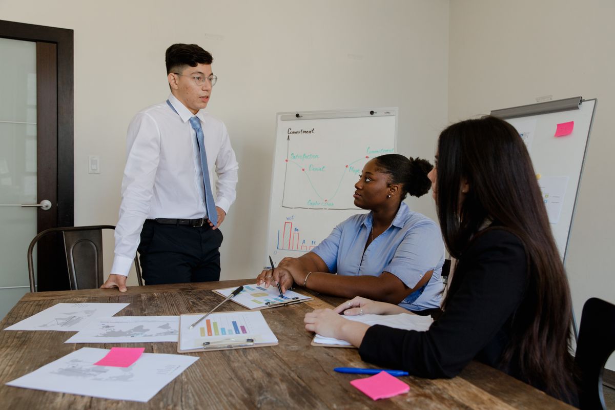A diverse leadership team gathered around a boardroom table in a business meeting