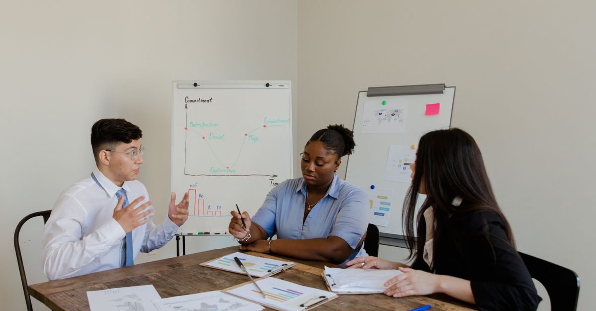 Diverse colleagues discussing plans during a corporate meeting indoors.