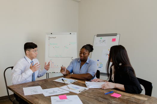 Diverse colleagues discussing plans during a corporate meeting indoors.