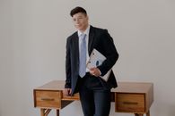 Man in Black Suit Holding White Printer Paper