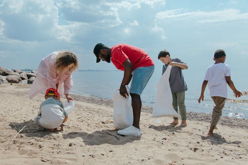 Free Man, Boys and Girl Cleaning Beach Stock Photo