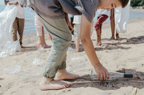 Free Kids participate in beach cleanup, collecting litter and promoting environmental care. Stock Photo
