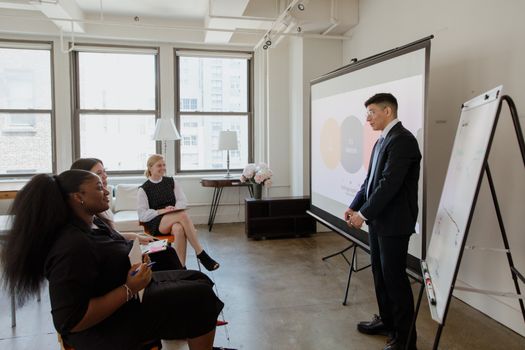 Professional business meeting with diverse team in a modern office setting.
