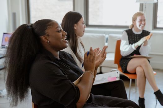 Women Sitting on Chairs while Clapping their Hands