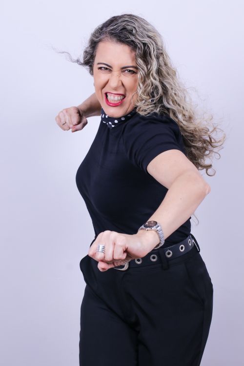 Free Strong and confident woman posing energetically in a studio setting. Stock Photo