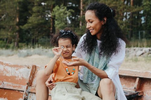 Free A joyful mother and daughter bonding in a natural outdoor setting, sharing smiles and happiness. Stock Photo