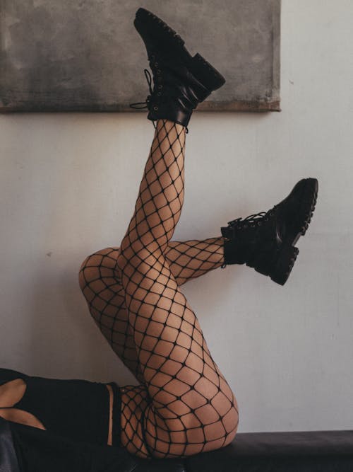 A Woman in Fishnet Tights and Boots Lying Down on the Floor