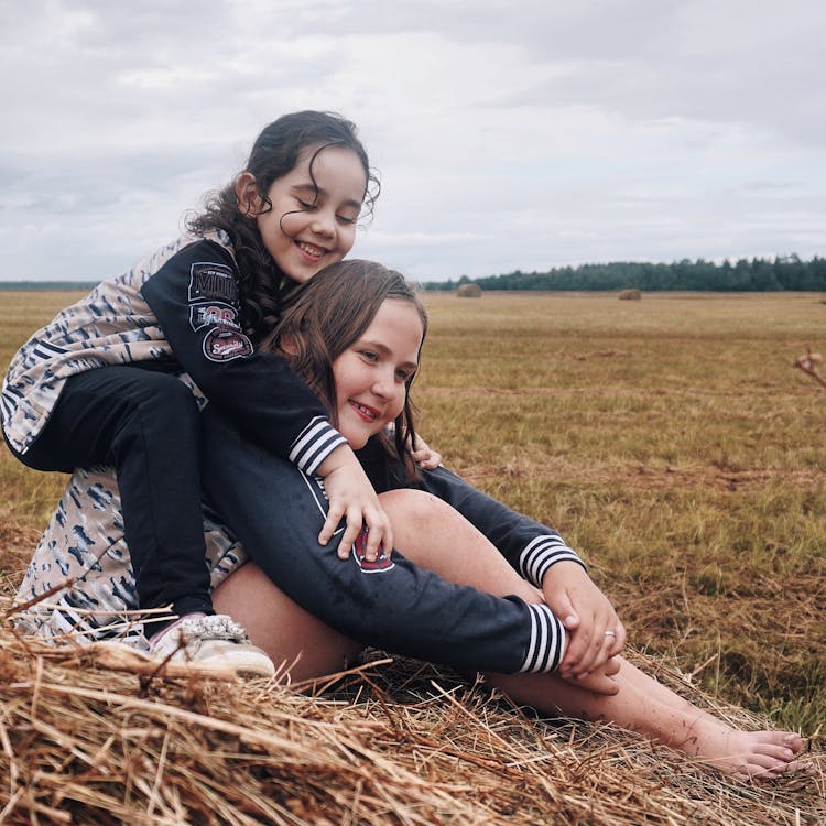 Girls Hugging On Hay