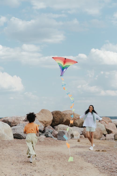 A Young Girl and a Woman Playing a Kite Together