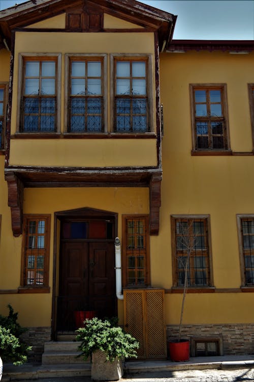Brown Wooden Door in Yellow Painted Building