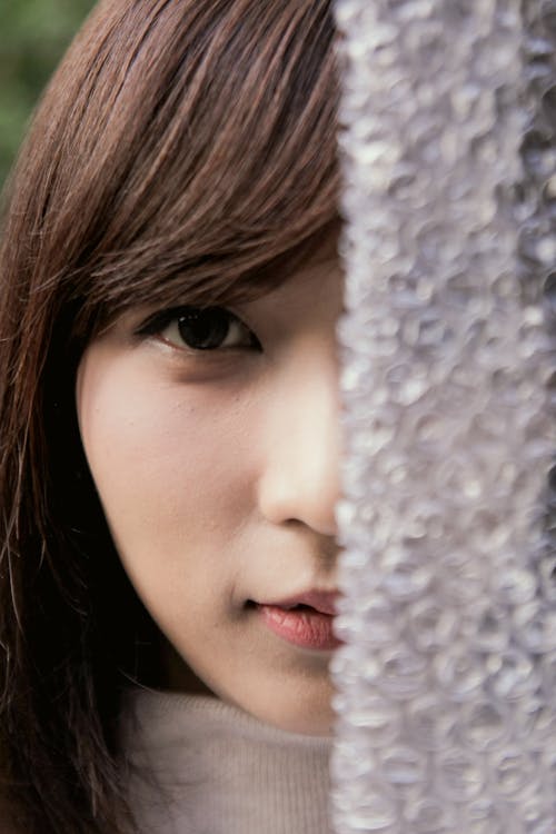 Gratis stockfoto met Aziatische vrouw, bedekkend gezicht, bubbeltjesplastic