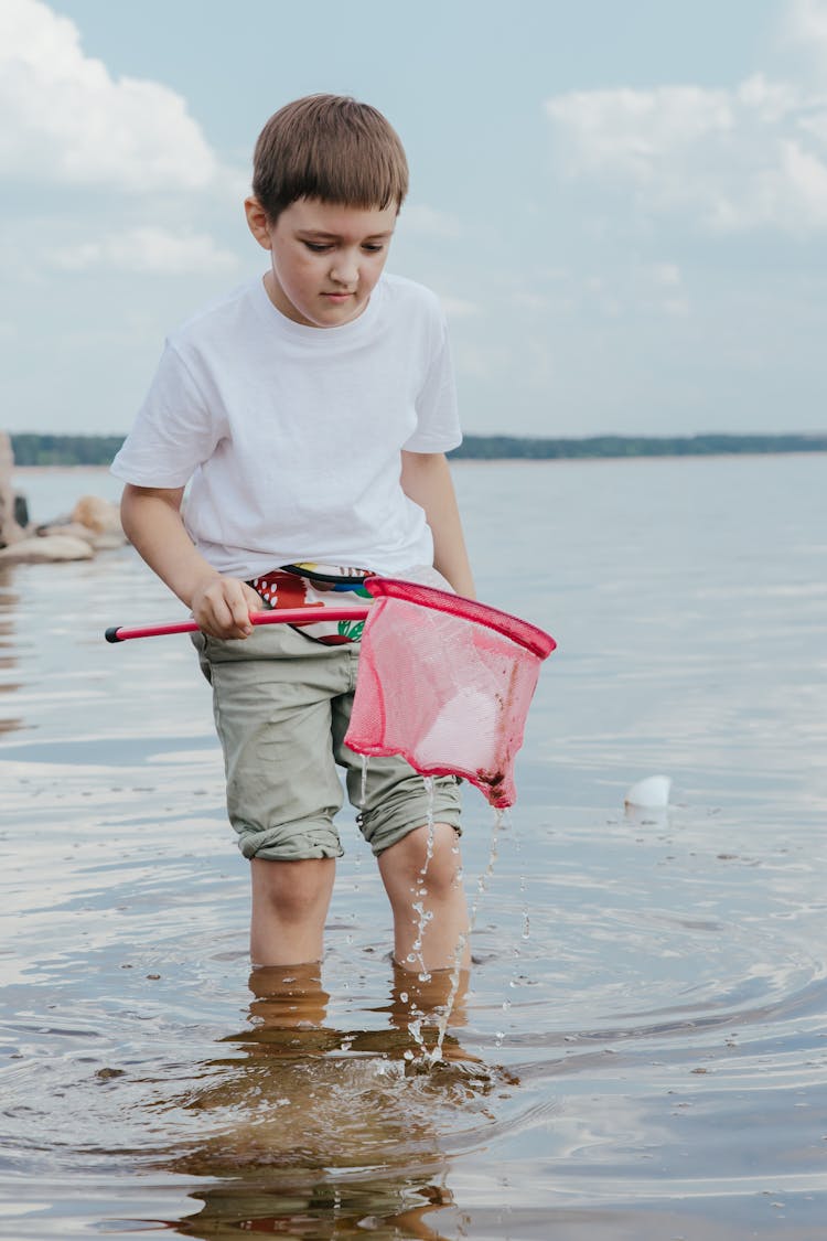 A Boy Cleaning At The Beach