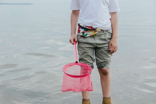 Person in White Shirt and Green Shorts Holding Pink Scrunch Net