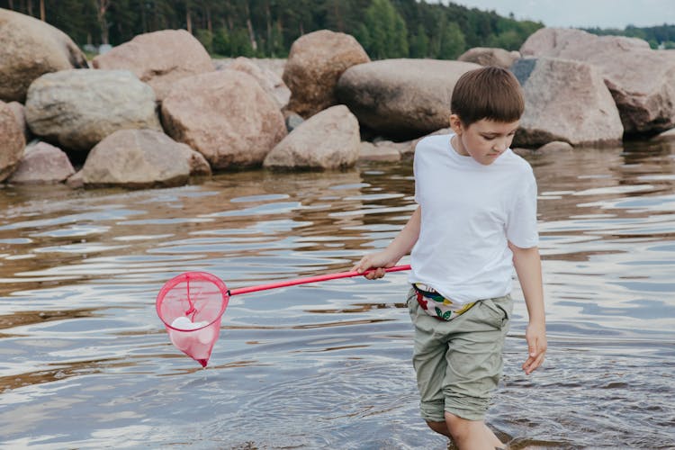 A Boy Cleaning At The Beach