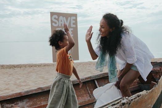 Mother and child high-five during a fun beach cleanup with a save the planet sign.