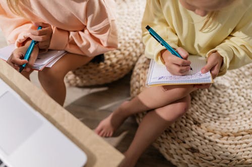 Free Young Girls Writing on their Notebooks Stock Photo