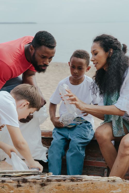 Free A group of diverse volunteers cleaning up a beach, promoting environmental conservation. Stock Photo