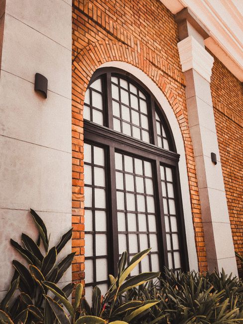 A detailed view of a modern brick building facade featuring an elegant arched window design.