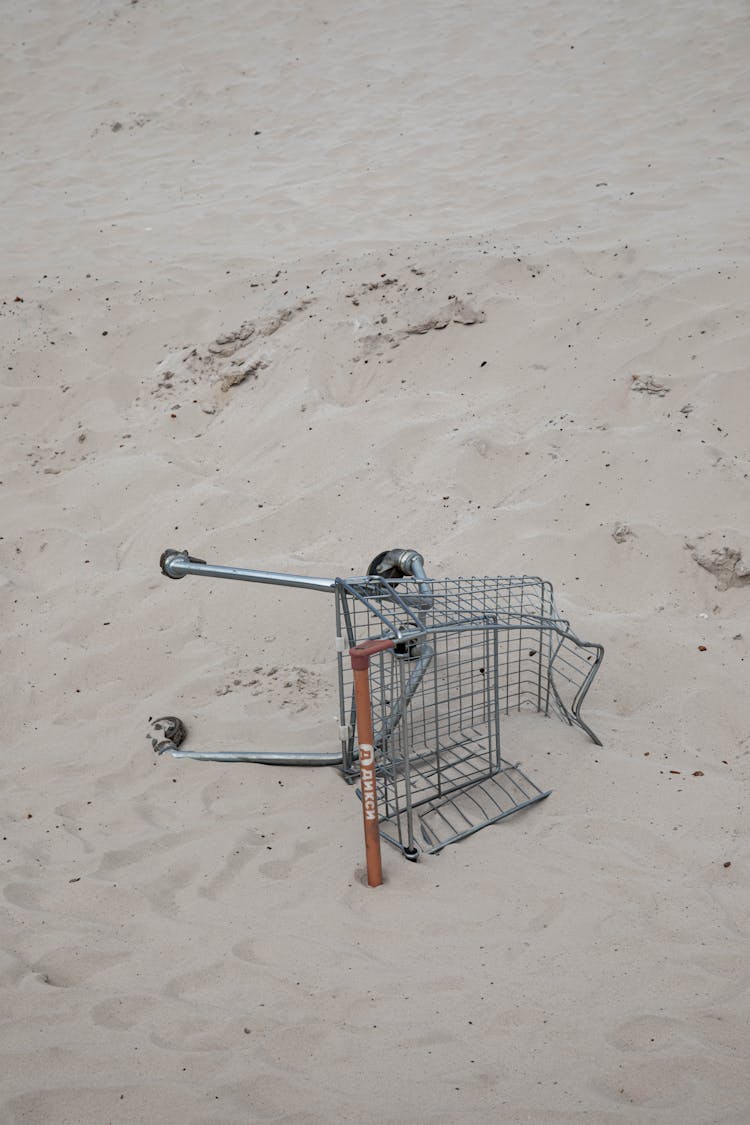 Supermarket Cart Lying In Sand