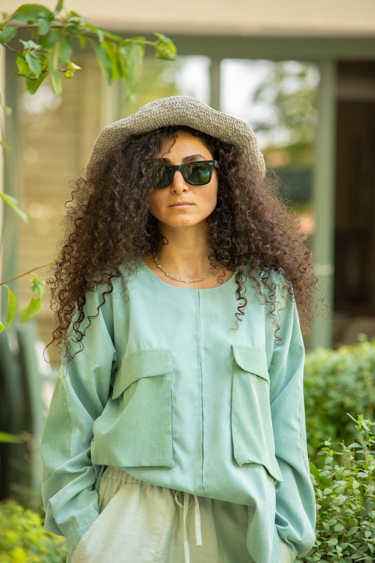 A Woman In Green Long Sleeves Wearing Black Sunglasses