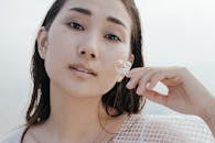 Woman in White and Black Polka Dot Shirt Holding White Flower