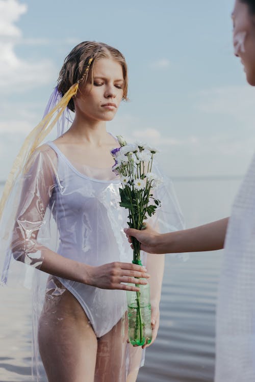 Woman in White Swimsuit Holding White Flower Bouquet