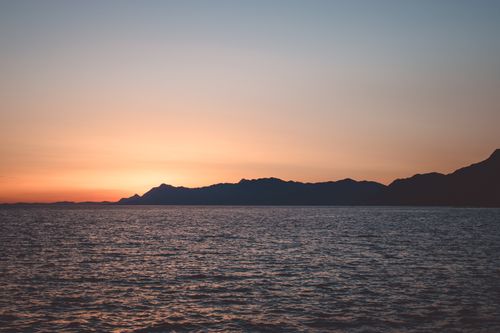 Free Peaceful sunset view over the Adriatic Sea with mountains silhouetted in Makarska, Croatia. Stock Photo