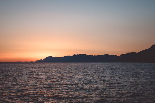 Free Stunning sunset view over the Adriatic Sea and mountains, creating a dramatic silhouette and tranquil atmosphere. Stock Photo