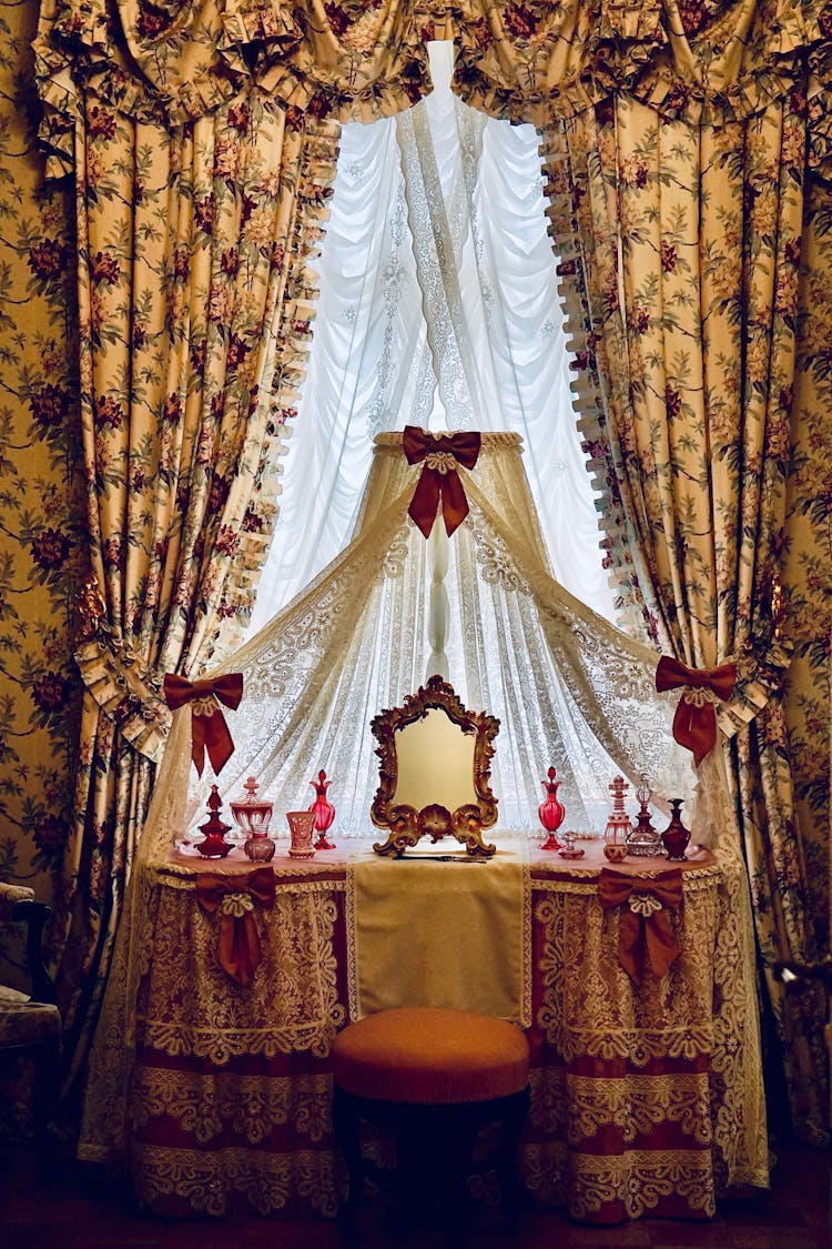 Floral Drapes And Lace Curtains On A Window