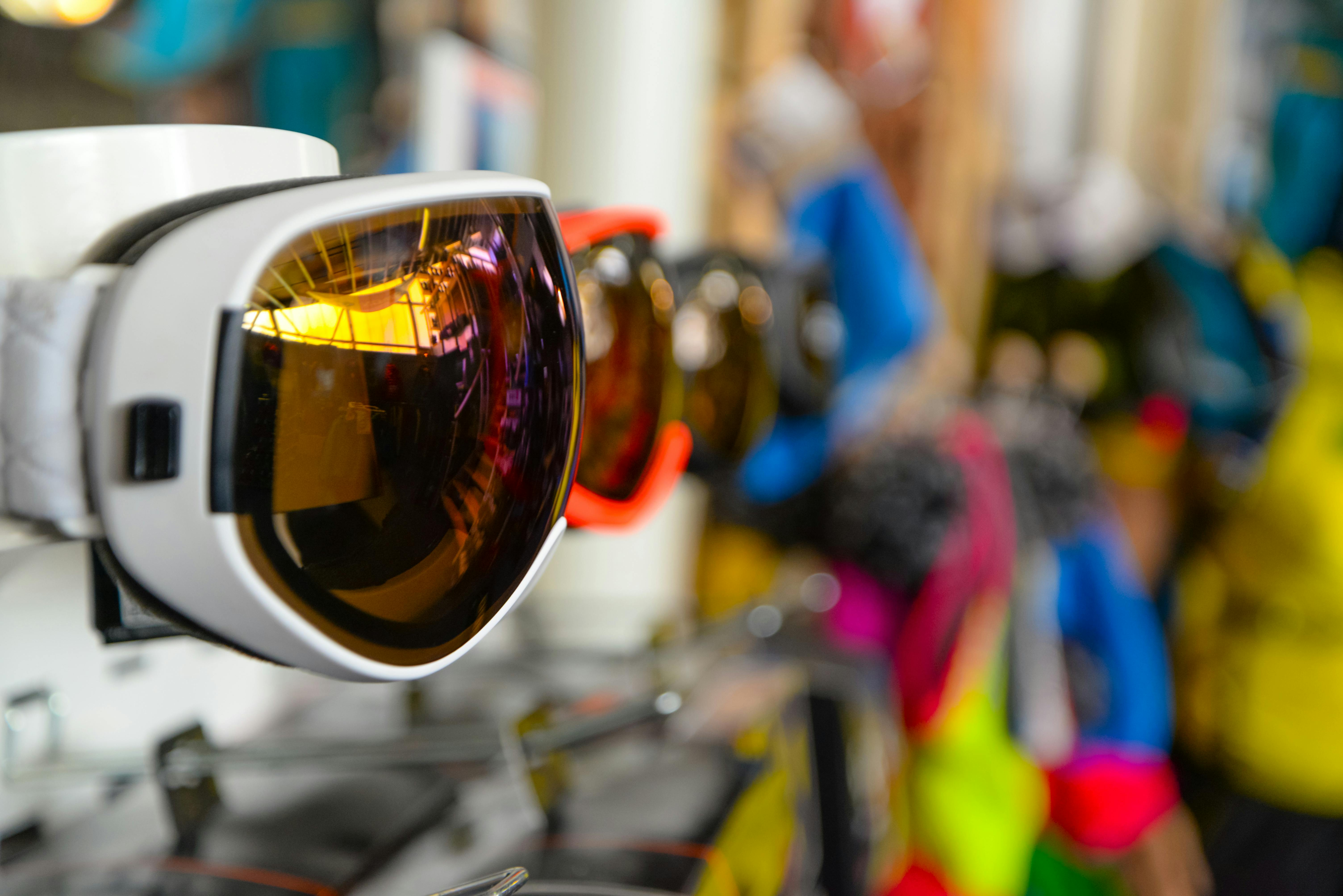 Prescription Goggle Inserts - Vibrant ski goggles displayed in a sports store, showcasing reflective lenses and colorful designs.