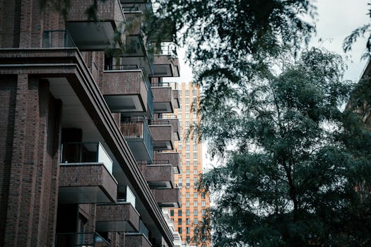 Low-angle view of brick residential buildings with lush greenery.