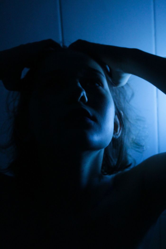 Portrait lit from behind in deep blue. Photo by Leyla Kasumova on Pexels.