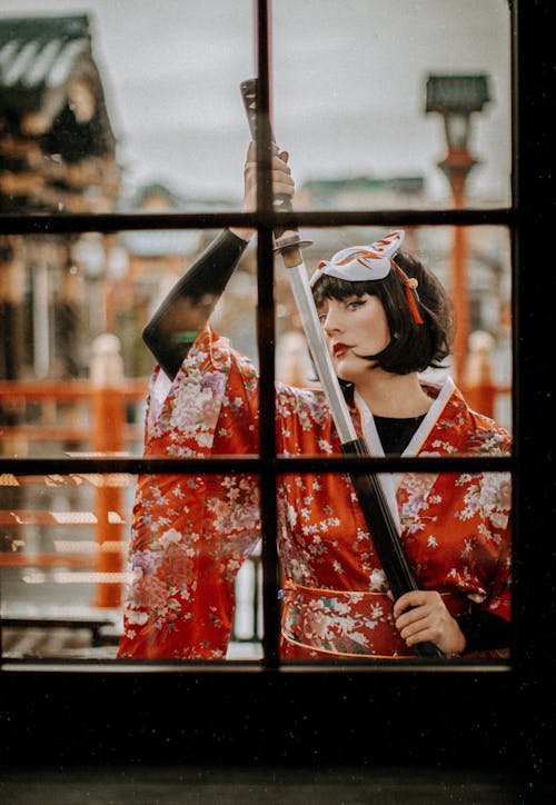 Free Woman Behind the Window Holding a Sword Stock Photo