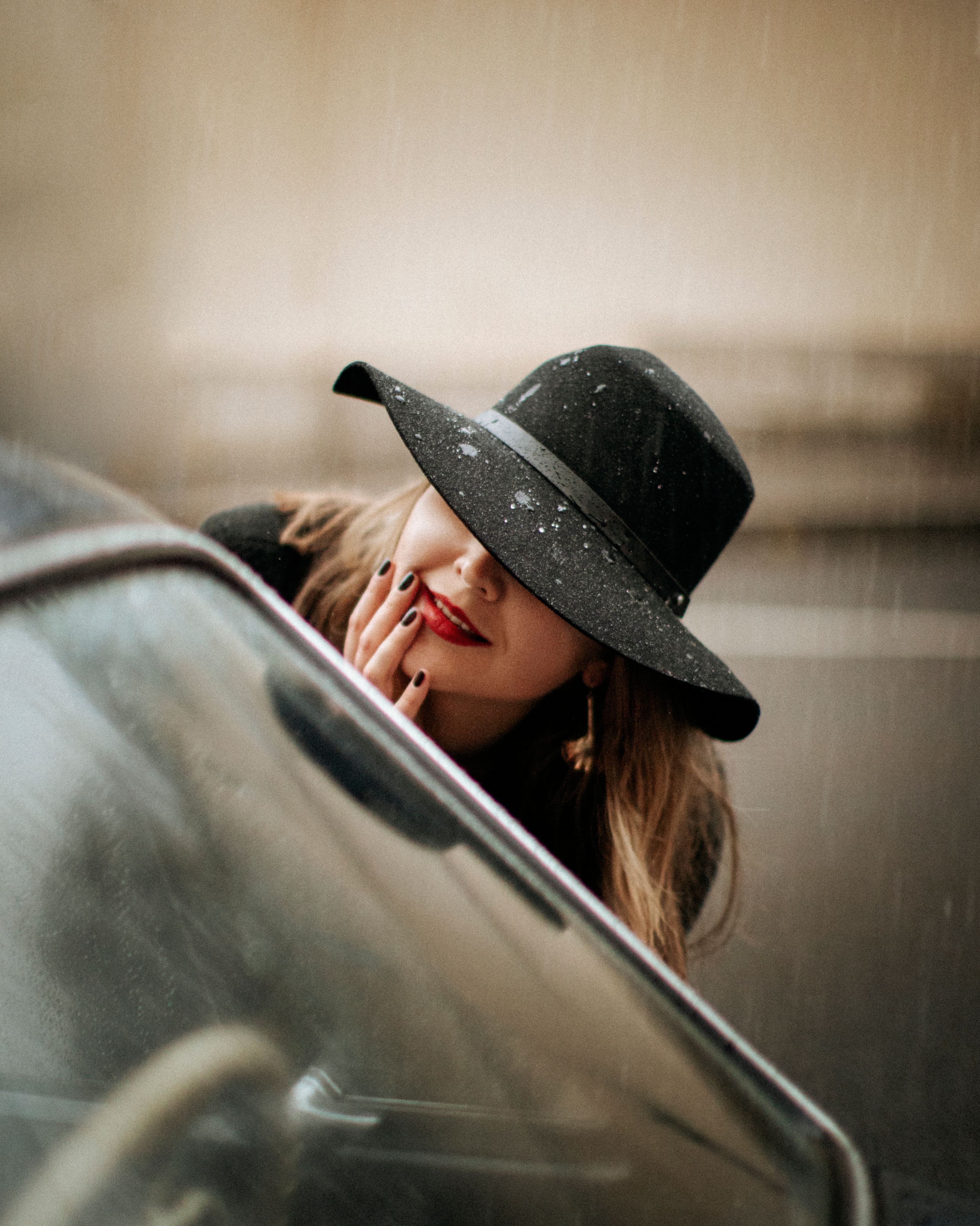 A Woman in Black Hat Looking at the Car Window · Free Stock Photo