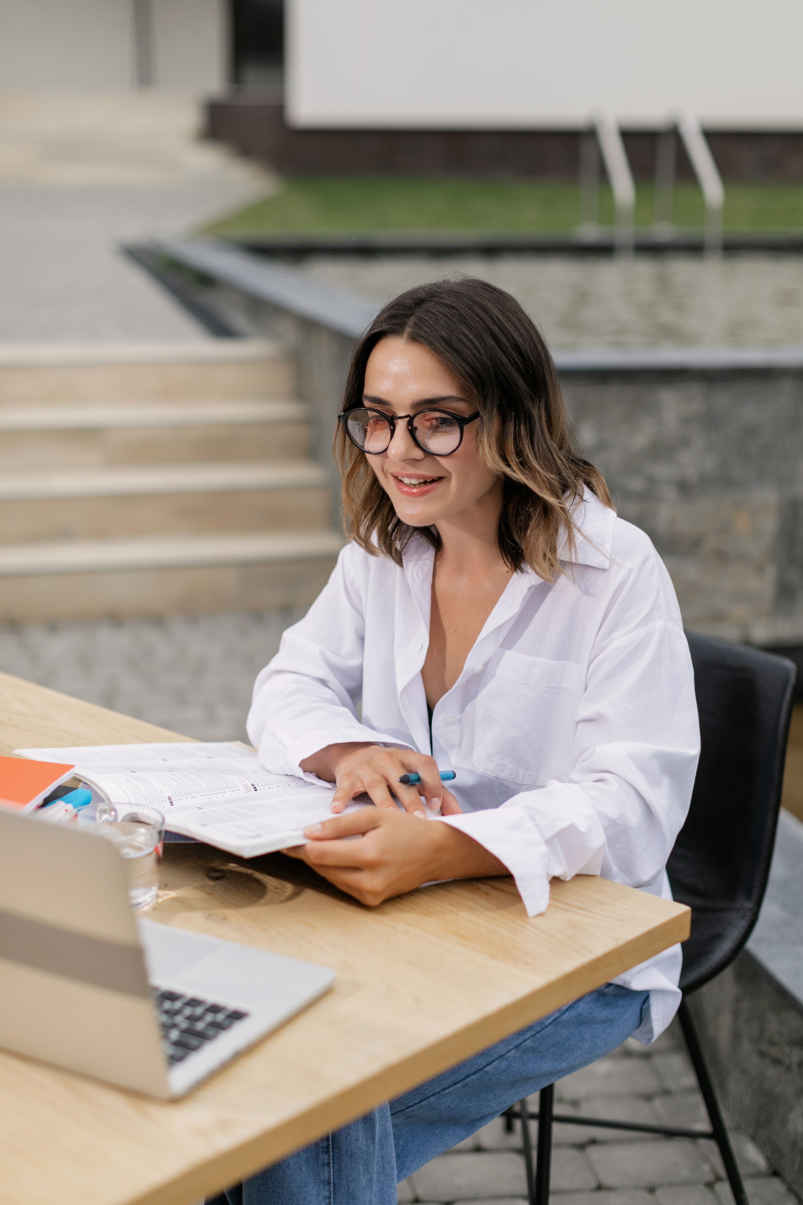 Woman in White Long Sleeve Shirt Sitting at Table with Laptop · Free ...