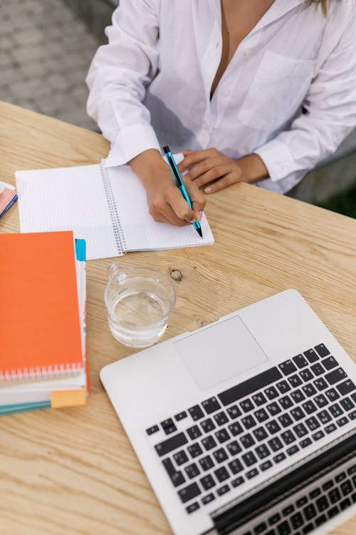 Person in White Long Sleeve Shirt Holding Blue Pen