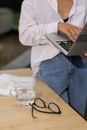 Person in White Long Sleeve Shirt and Blue Denim Jeans Using Macbook Pro