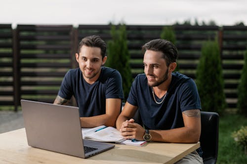 Twin Brothers Looking at Laptop Screen Together