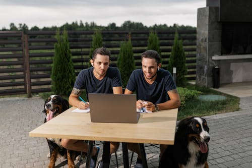 Men Sitting at the Table while Using Laptop