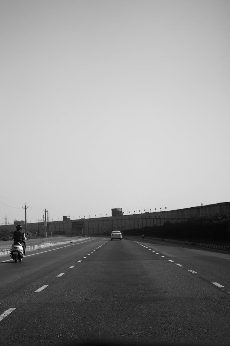 Monochrome Photo Of A Vehicle And Motorcycle On Highway