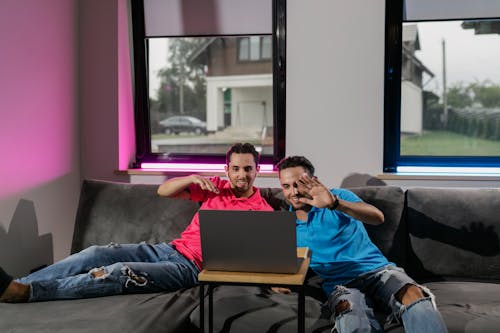 Men in Denim Ripped Jeans Sitting on Couch 