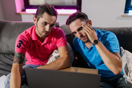 Man in Red Polo Shirt Sitting Beside Man in Blue Polo Shirt