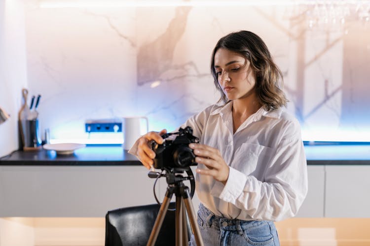 Woman In White Dress Shirt Setting Up Her Camera